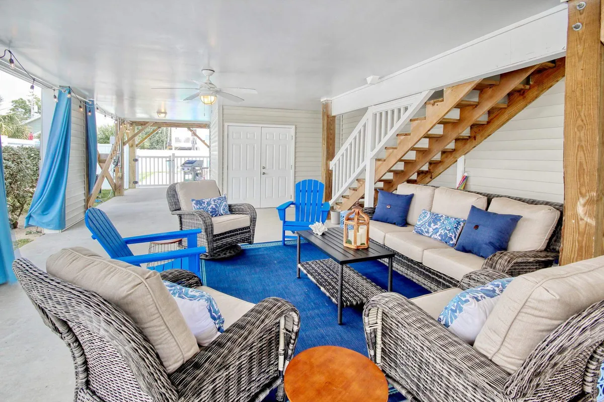 A comfortable indoor seating area with decorative cushions, a coffee table, and a staircase in the background. The inviting atmosphere suggests a space for conversation, casual gatherings, or relaxing after a day outdoors.